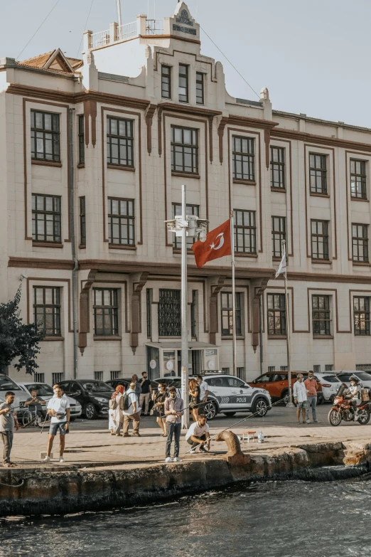 a group of people standing in front of a building, by Tamas Galambos, pexels contest winner, danube school, danish flag, turkey, on a great neoclassical square, reykjavik junior college