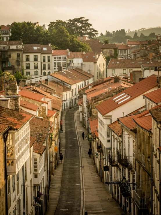 a street filled with lots of buildings next to tall buildings, by Nadir Afonso, pexels contest winner, renaissance, tiled roofs, arrendajo in avila pinewood, slide show, moody morning light