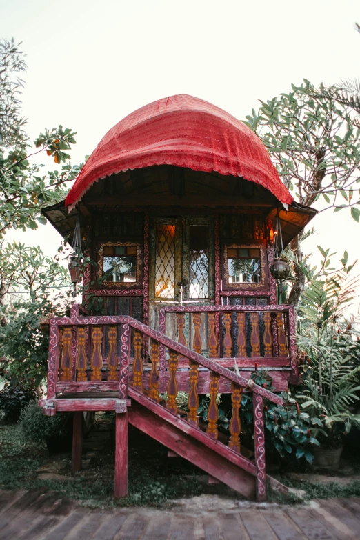 a small wooden house with a red roof, justina blakeney, ornate retreat, shambala, vine covered