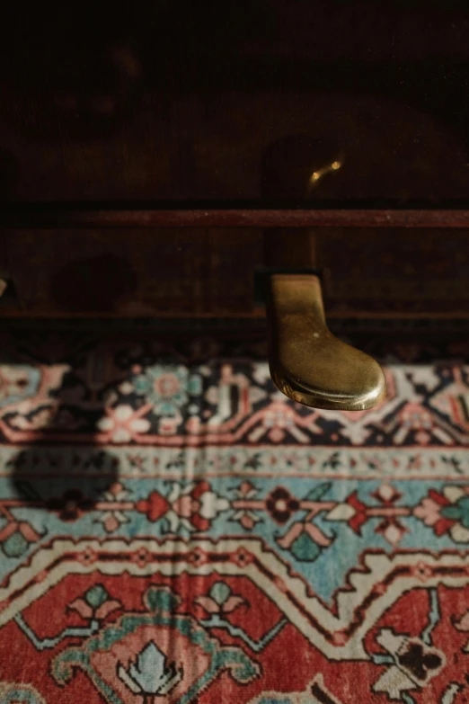 a pair of shoes sitting on top of a rug, an album cover, unsplash, hurufiyya, the grand steampunk piano, william eggleston, persian carpet, depth detail