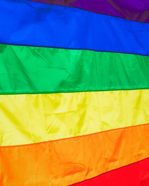 a rainbow flag hanging from the side of a building, profile image, zoomed in, gang flags, up-close