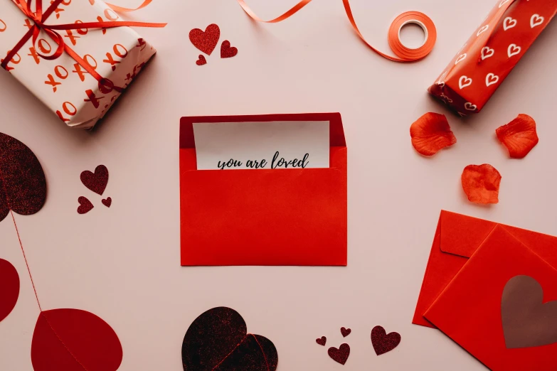 a couple of red envelopes sitting on top of a table, by Julia Pishtar, pexels contest winner, mail art, romantic lead, makeup, lettering, lovecratian