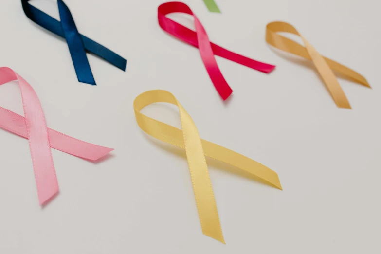 a number of different colored ribbons on a white surface, by Gavin Hamilton, trending on pexels, antipodeans, tumors, close up shot from the side, pink and yellow, male and female