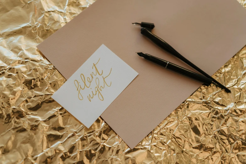 a pen sitting on top of a piece of paper, by Julia Pishtar, pexels contest winner, aestheticism, gold foil, card template, it's night, background image