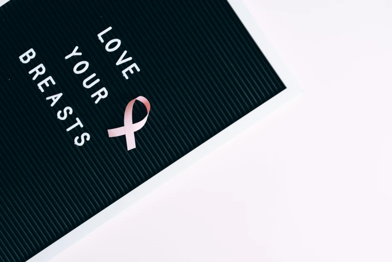 a black board with a pink ribbon on it, a polaroid photo, by Justus van Gent, pexels contest winner, love is the most relevant theme, background image, cysts, minimalistic logo