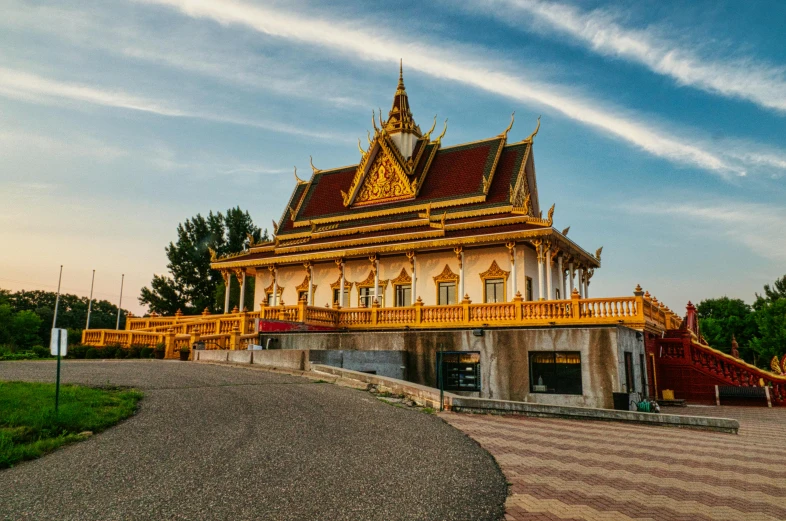 a large building sitting on top of a lush green field, unsplash, futuristic phnom-penh cambodia, ornate gold, profile image, shoreline