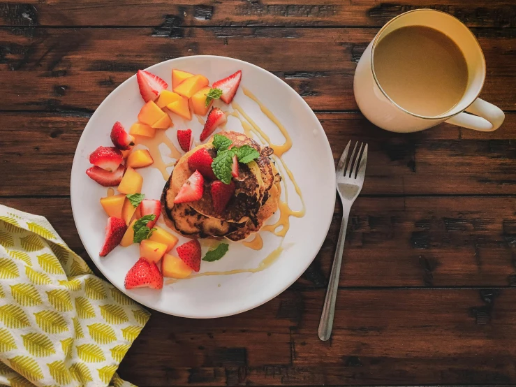 a white plate topped with fruit next to a cup of coffee, pexels contest winner, pancake flat head, summer vibrancy, manuka, thumbnail