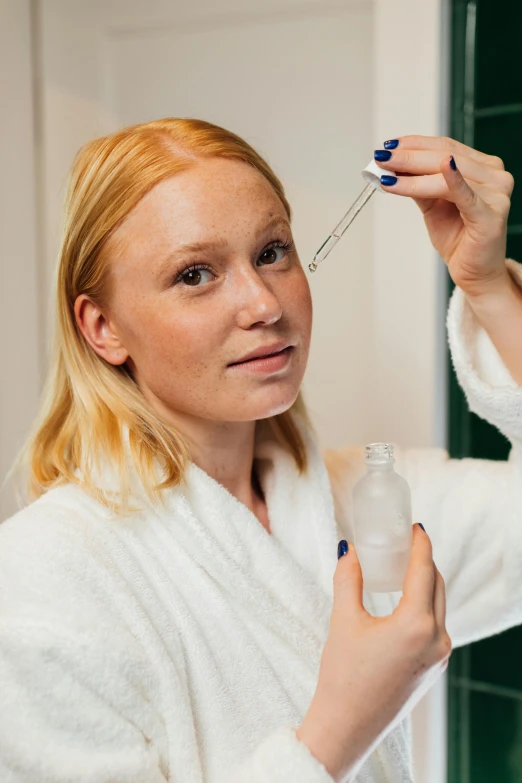 a woman in a bathrobe brushing her teeth, inspired by Louisa Matthíasdóttir, trending on reddit, synthetic bio skin, holding a bottle of arak, high forehead, close-up product photo