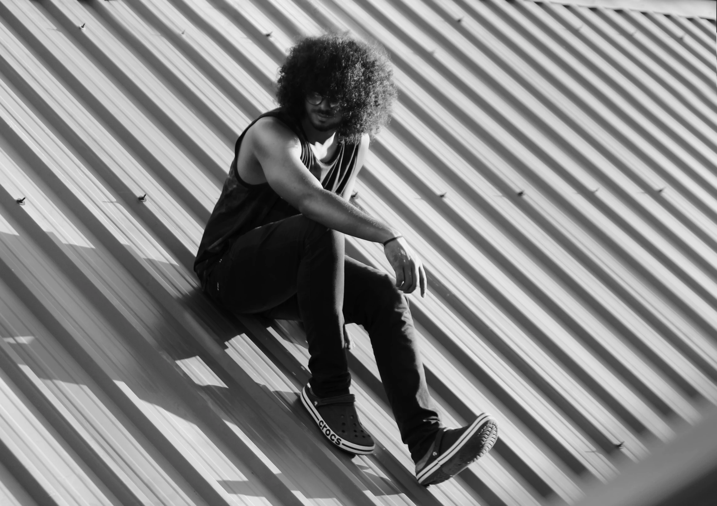 a man sitting on top of a metal roof, a black and white photo, by Maurycy Gottlieb, pexels, curly afro, sitting on the floor, suicide, black female