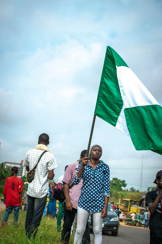 a group of people holding a green and white flag, by Chinwe Chukwuogo-Roy, trending on unsplash, happening, square, a pilgrim, adebanji alade, slide show