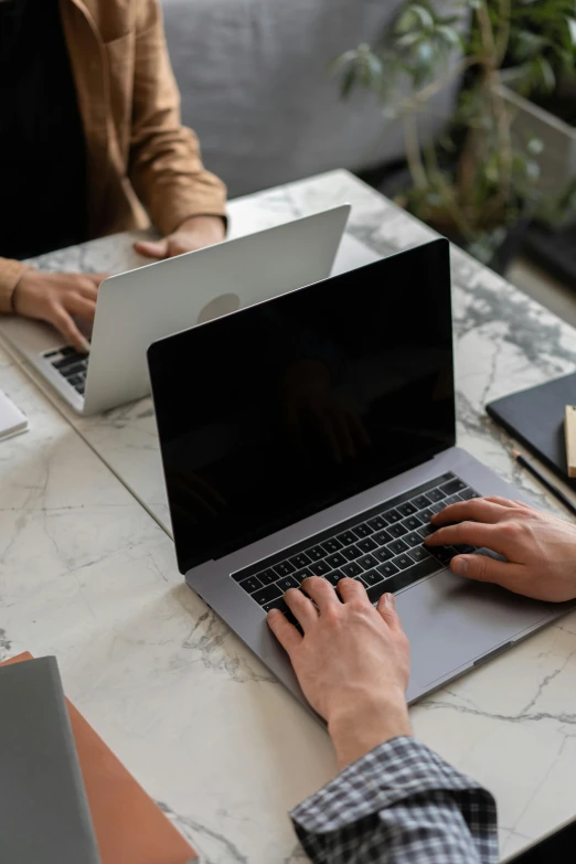 a couple of people sitting at a table with laptops, by Carey Morris, pexels, zoomed in, creative coder with a computer, thumbnail, screensaver