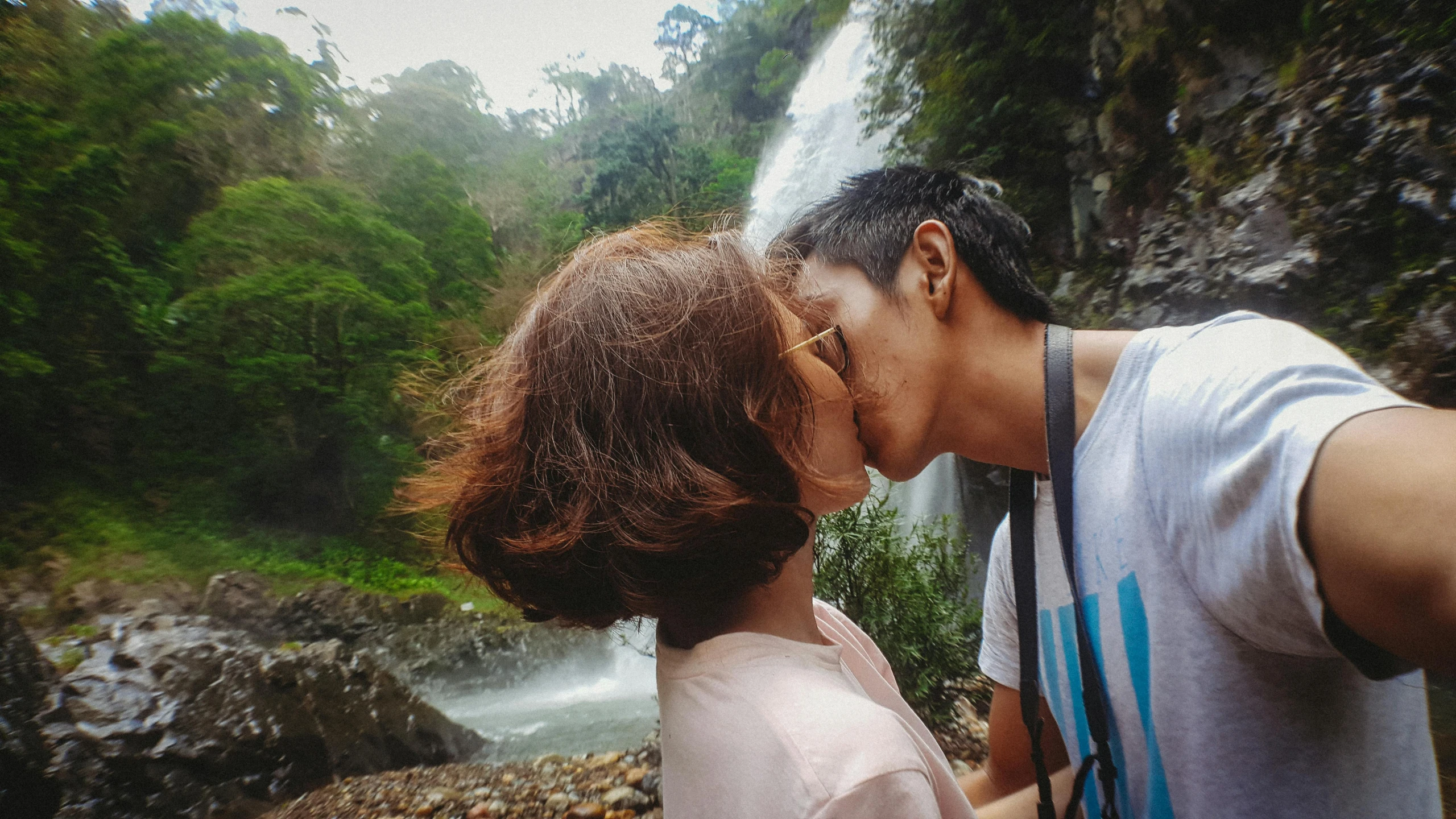 a man and a woman kissing in front of a waterfall, pexels contest winner, sumatraism, 😭🤮 💔, lesbians, taiwan, avatar image