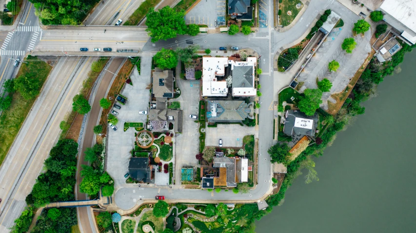 an aerial view of a city next to a river, by Carey Morris, unsplash, photorealism, bentonville arkansas, streetscapes, vegetated roofs, 2 0 2 2 photo