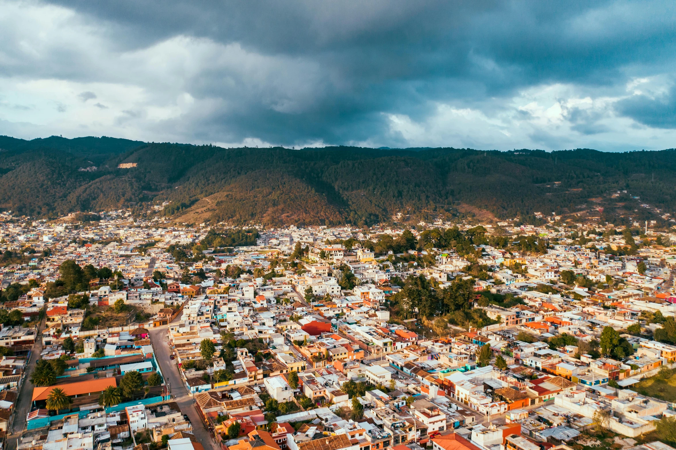 an aerial view of a city with mountains in the background, by Alejandro Obregón, pexels contest winner, quito school, ultrawide angle cinematic view, square, background image, multi - coloured