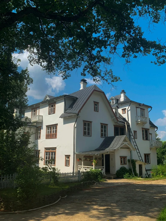 a large white house sitting on top of a lush green field, a photo, inspired by Rudolf von Alt, unsplash, art nouveau, stålenhag, seen from outside, cottagecore!!, low quality photo