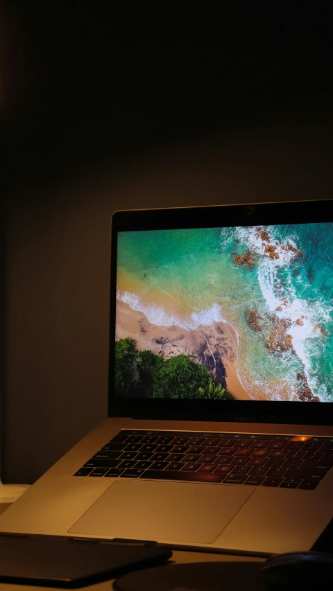 a laptop computer sitting on top of a desk, by Robbie Trevino, pexels, dramatic lighting from above, a photo of the ocean, thumbnail, 8 k hi - res