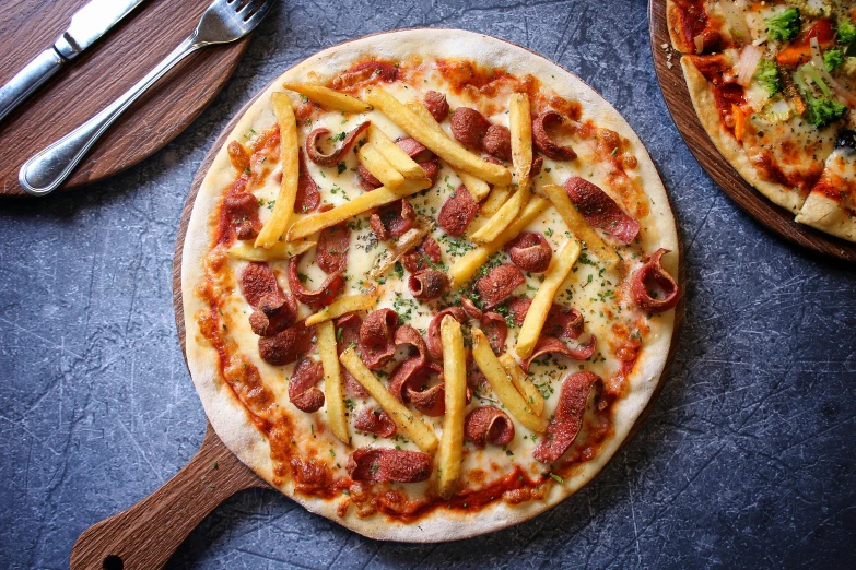 a couple of pizzas sitting on top of a table, with fries, chorizo sausage, 2 1 0 mm, star