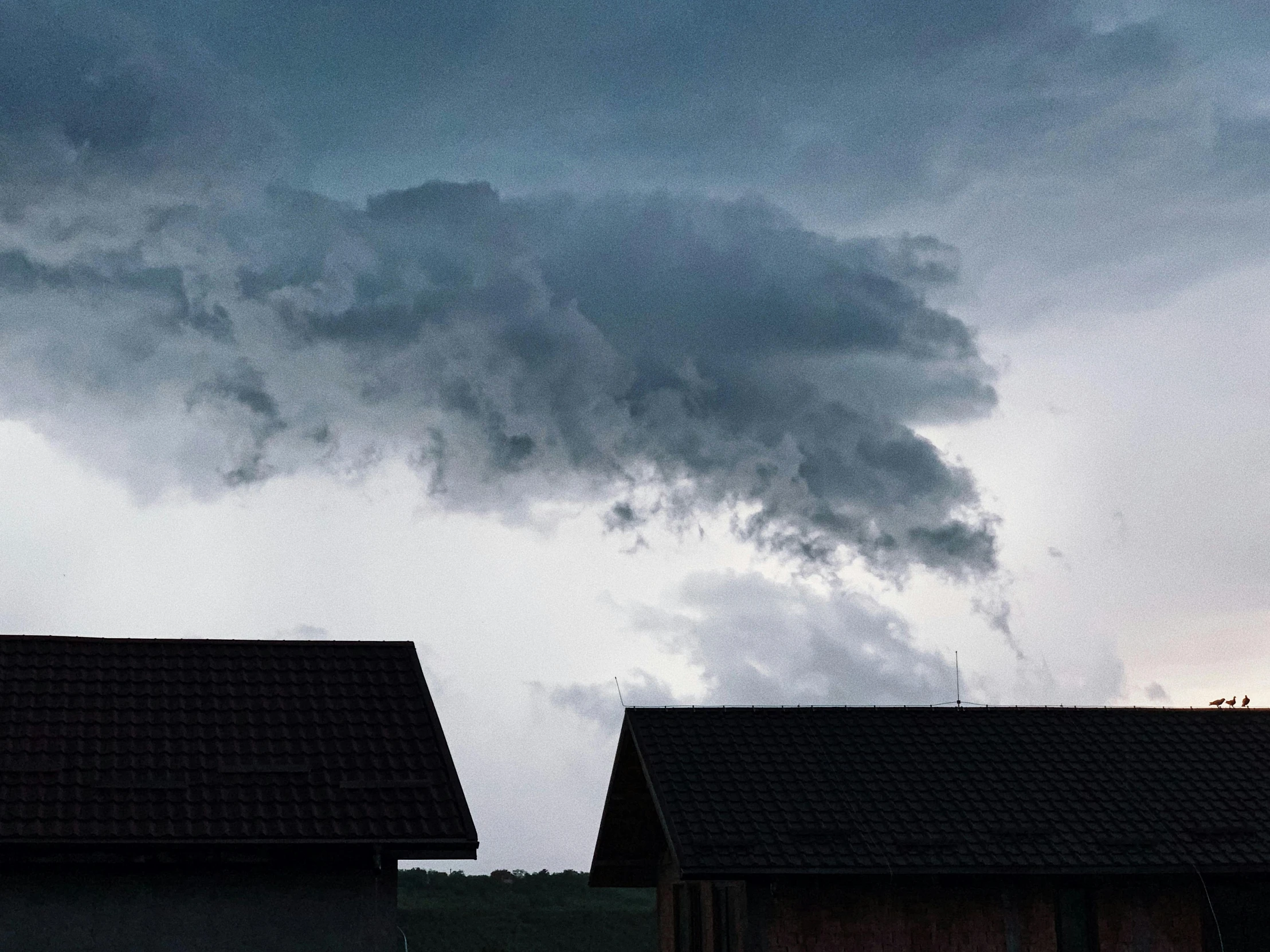 a couple of houses sitting next to each other under a cloudy sky, a picture, pexels contest winner, precisionism, explosive storm, hd footage, grey, storm in the evening