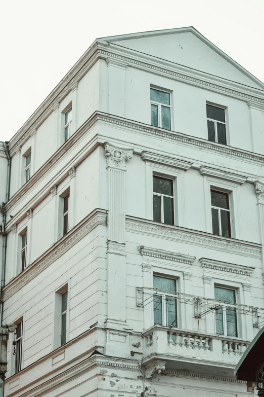 a tall white building with many windows and balconies, by Adam Marczyński, pexels contest winner, neoclassicism, russian style, background image, vintage photo, seen from outside