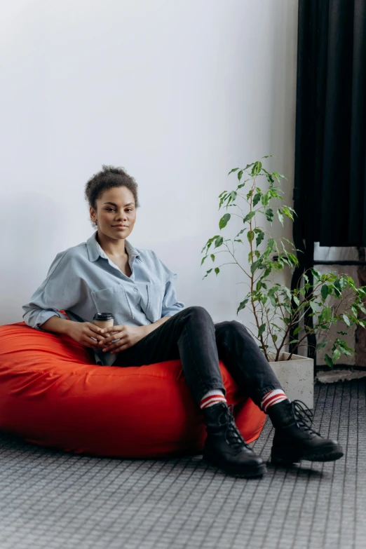 a woman sitting on a bean bag chair, a portrait, trending on unsplash, in an office, 9 9 designs, tessa thompson, maximus jacobs