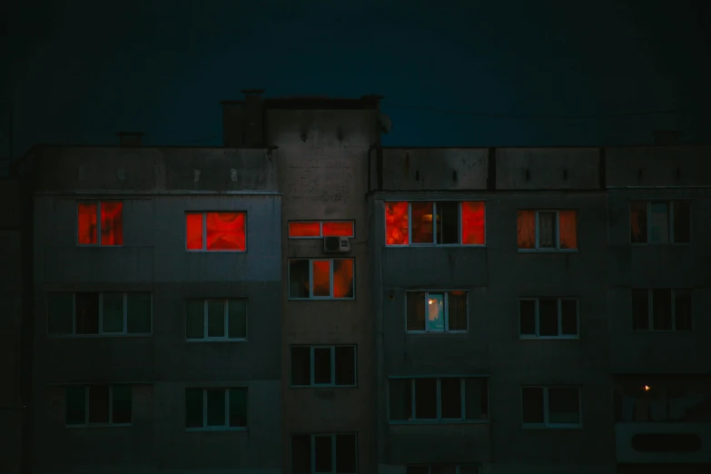 a tall building with windows lit up at night, an album cover, inspired by Elsa Bleda, pexels contest winner, socialist realism, bright red, azamat khairov, halloween night, no lights in bedroom