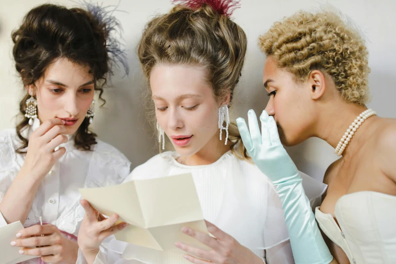 three women in white dresses are looking at a piece of paper, inspired by Jean-Étienne Liotard, trending on pexels, rococo, 8 0's hairstyle, white long gloves, coloured, white ascot