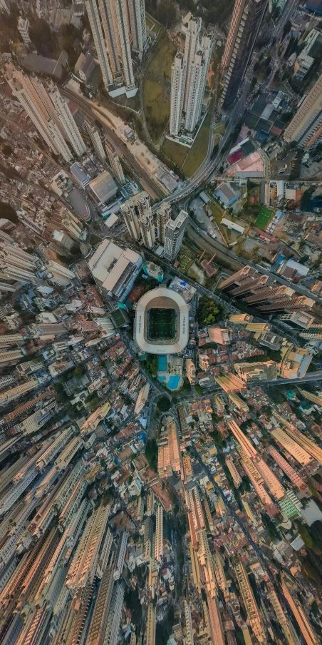 an aerial view of a city with tall buildings, an album cover, by Luis Miranda, pexels contest winner, soccer stadium, wideangle, kowloon, moroccan city