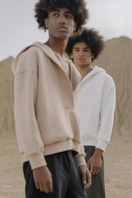 two men standing next to each other in the desert, inspired by Raphaël Collin, renaissance, wearing a hoodie and sweatpants, light cream and white colors, zoomed in, thumbnail