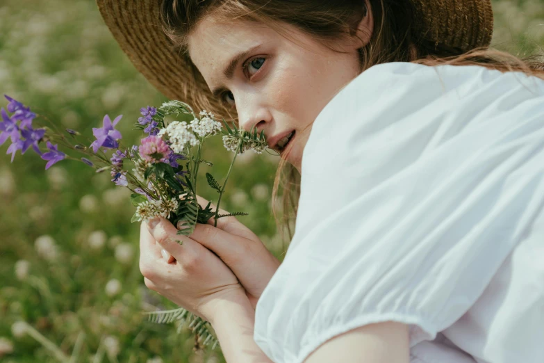 a woman in a hat holding a bunch of flowers, pexels contest winner, renaissance, meadow flowers, side portrait imagery, girl with brown hair, wearing white clothes