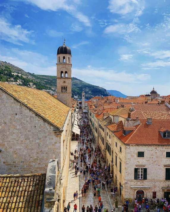 a crowd of people walking down a street next to tall buildings, pexels contest winner, renaissance, dubrovnik, thumbnail, stone roof, square