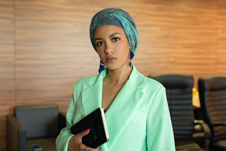 a woman wearing a turban holding a book, pexels, hurufiyya, wearing a blazer, teal suit, office clothes, mixed race woman