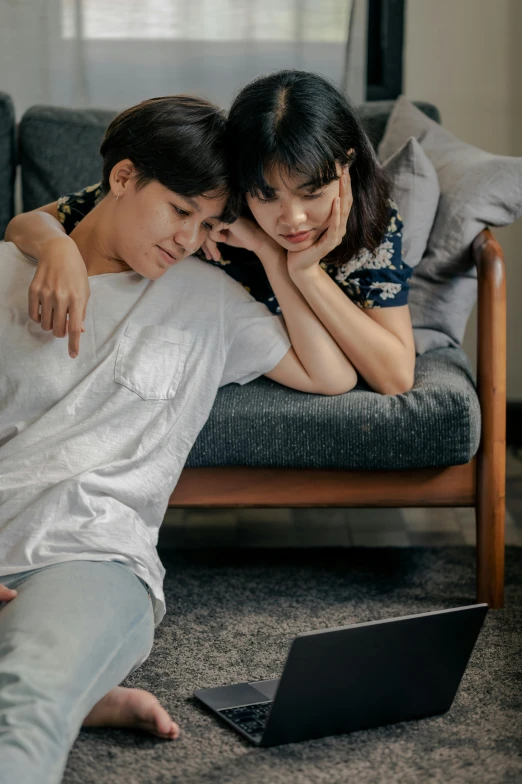 a man and woman sitting on a couch looking at a laptop, pexels contest winner, happening, asian girl, lesbian embrace, jakarta, ( ( theatrical ) )