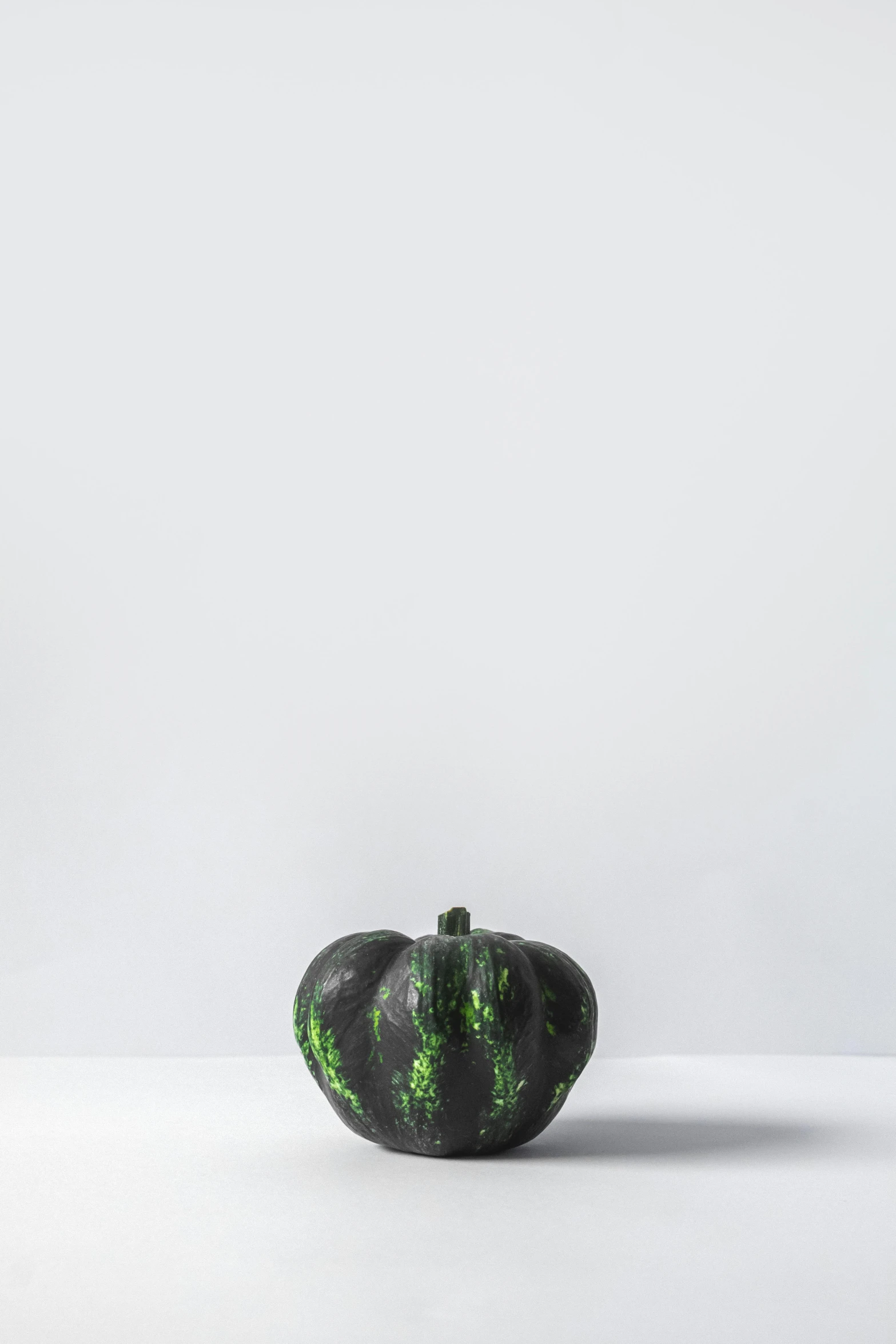 a black and green pumpkin sitting on top of a table, a digital rendering, unsplash, 2 5 6 x 2 5 6 pixels, black resin, spotted ultra realistic, productphoto