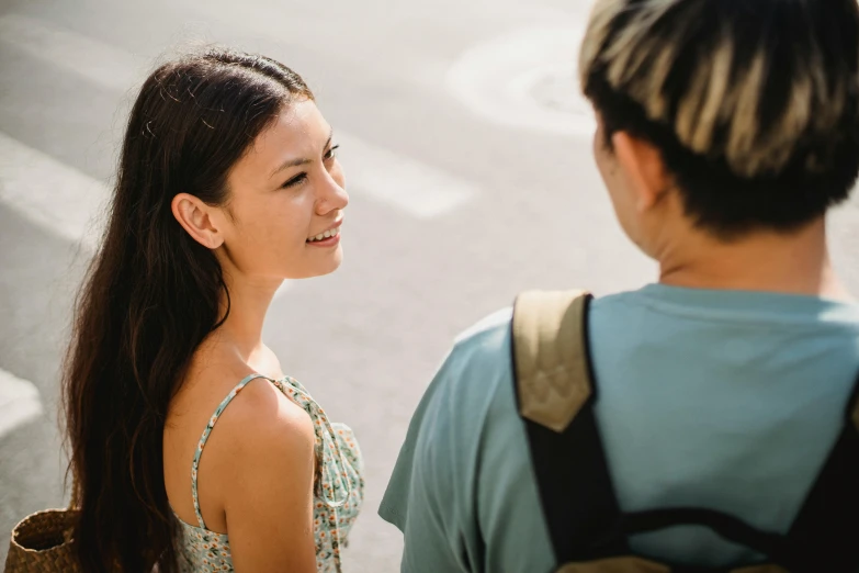 a woman standing next to a man on a street, trending on pexels, brown hair in a ponytail, talking, avatar image, asian woman