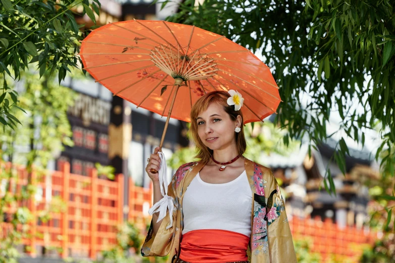 a woman in a kimono is holding an umbrella, a portrait, pixabay, white and orange, portrait image, tourist photo, on location