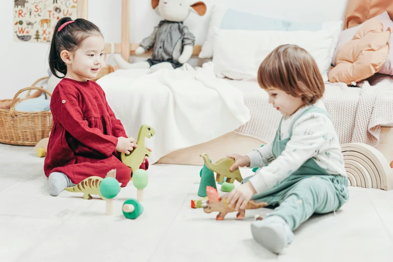 two children sitting on the floor playing with toys, by Emma Andijewska, pexels contest winner, dinosaur wooden statue, walking to the right, thumbnail, 1 2 9 7