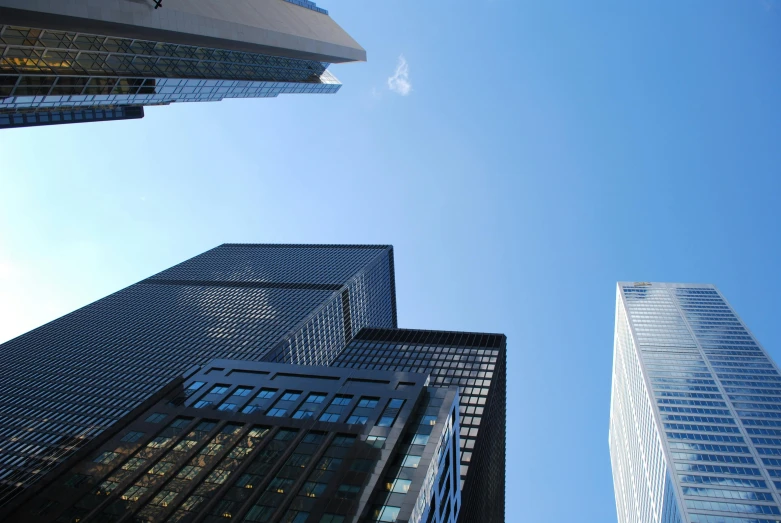 some very tall buildings in a big city, pexels contest winner, photorealism, toronto, clear blue sky, mies van der rohe, photos