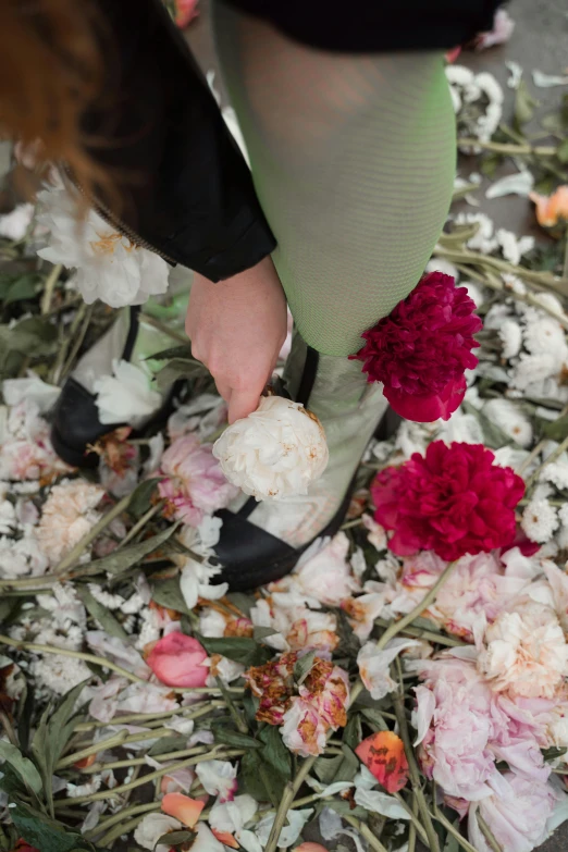 a woman standing on top of a pile of flowers, inspired by Vanessa Beecroft, trending on unsplash, silk shoes, walk in a funeral procession, peony flowers, tearing