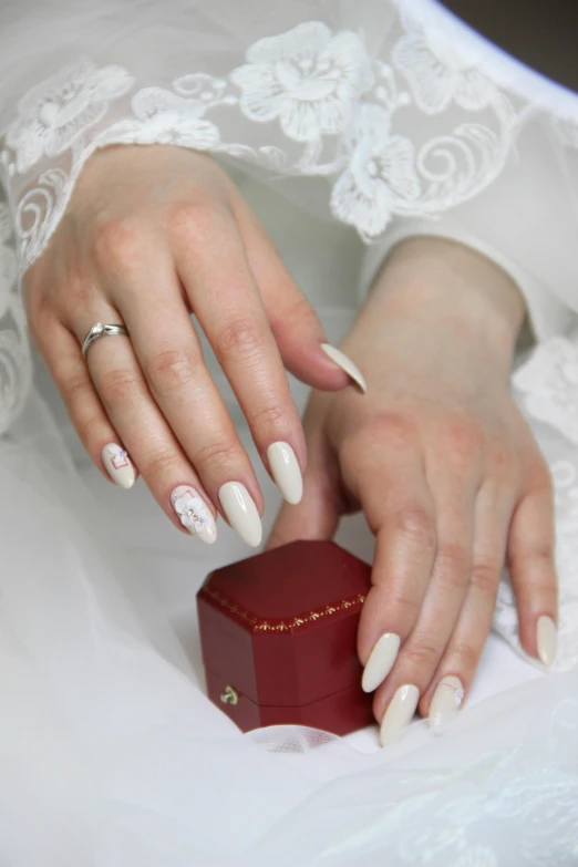 a woman in a white dress holding a red box, a tattoo, inspired by L. A. Ring, pexels contest winner, romanticism, neat nails, silver，ivory, “diamonds, cas