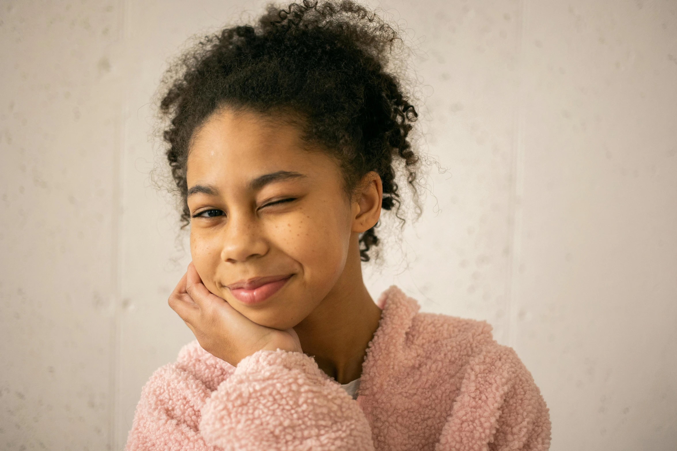 a close up of a person wearing a pink sweater, a character portrait, trending on pexels, black teenage girl, little shy smile, morning mood, confident relaxed pose