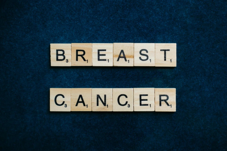 two scrabbles spelling breast cancer on a blue background, an album cover, pixabay, alessio albi, on black background, mid 2 0's female, a wooden