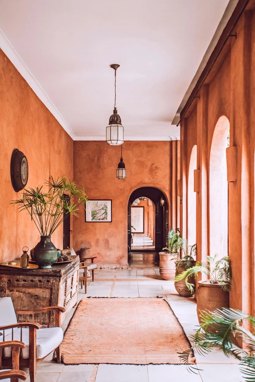 a long hallway with chairs and potted plants, inspired by Riad Beyrouti, pexels contest winner, light and space, orange hue, located in a castle, exterior, rustic and weathered