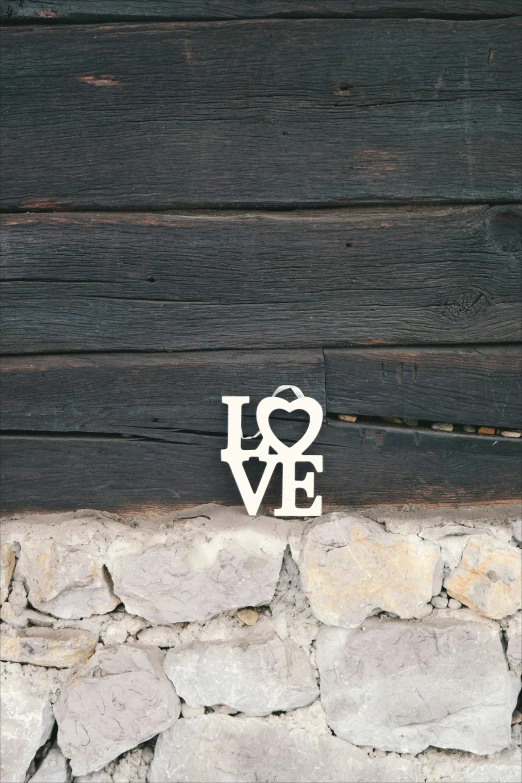 a stone wall with a love sign on it, a picture, unsplash, wooden decoration, silver，ivory, 1x, large tall