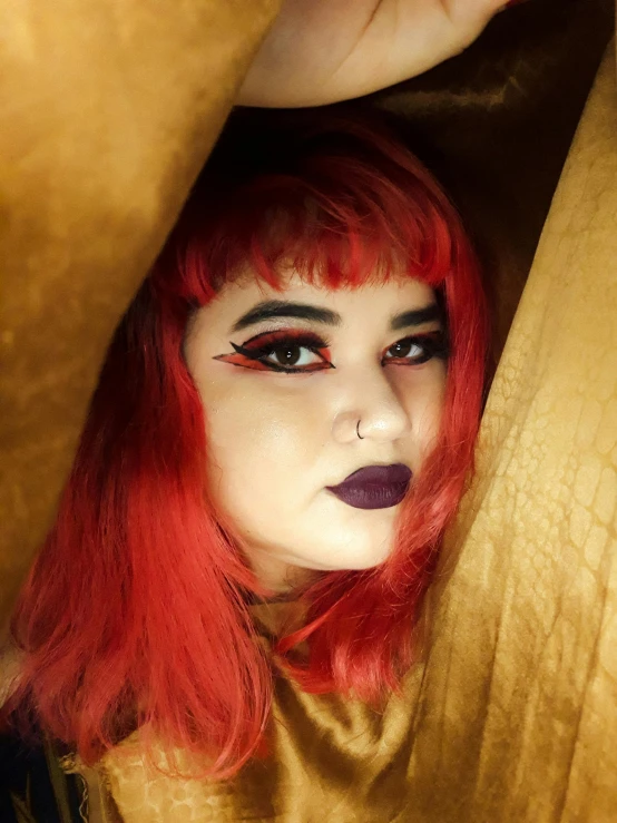 a close up of a person with red hair, reddit, lowbrow, egyptian makeup, dark gold hair, album photo, grainy photo