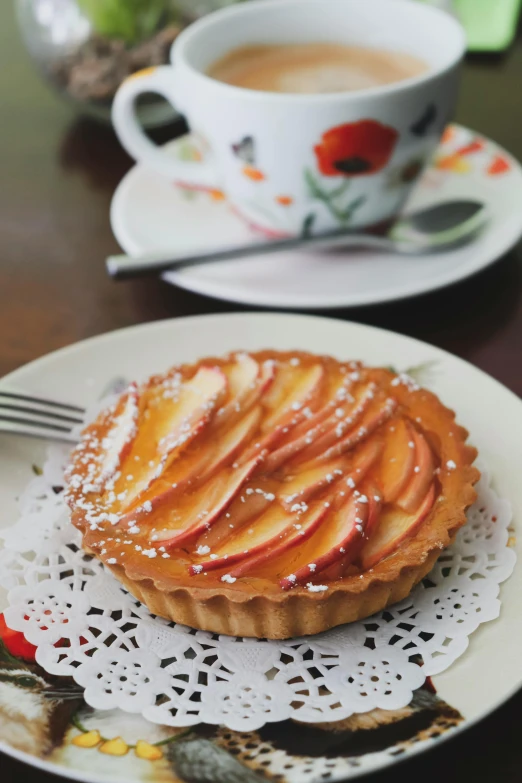 a white plate topped with a pastry next to a cup of coffee, inspired by Richmond Barthé, renaissance, apples, crown of peach roses, 2 5 6 x 2 5 6 pixels, full body close-up shot