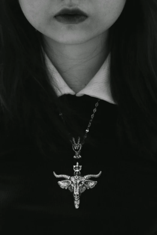 a black and white photo of a woman with long hair, a black and white photo, inspired by Elsa Bleda, unsplash, surrealism, baphomet, pendant, crucifix, dark university aesthetic