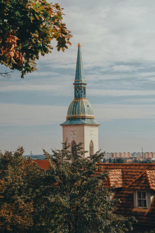 a clock tower on top of a building next to trees, by Adam Szentpétery, trending on unsplash, baroque, lead - covered spire, looking over city, sunfaded, hungarian