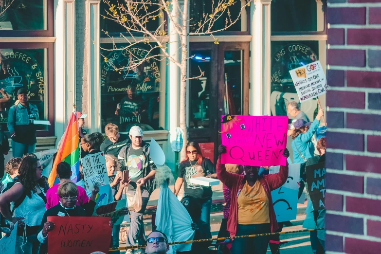 a group of people holding signs in front of a building, pexels, queer, background image, parade, from wheaton illinois