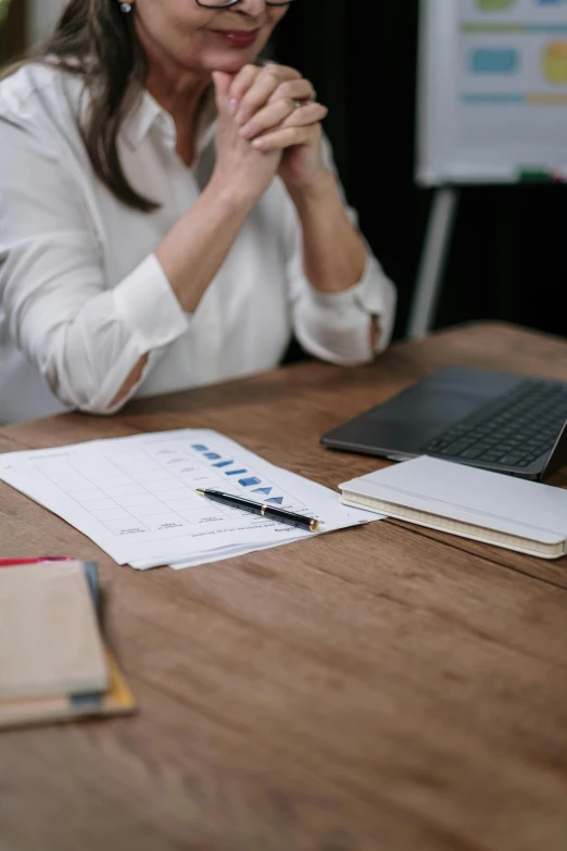 a woman sitting at a table in front of a laptop computer, trending on pexels, analytical art, charts, low quality photo, thumbnail