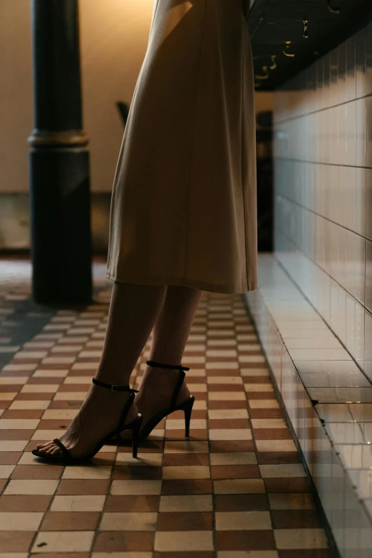 a woman in high heels standing on a tiled floor, trending on unsplash, renaissance, low light cinematic, fashion editorial, modest, standing in a restaurant